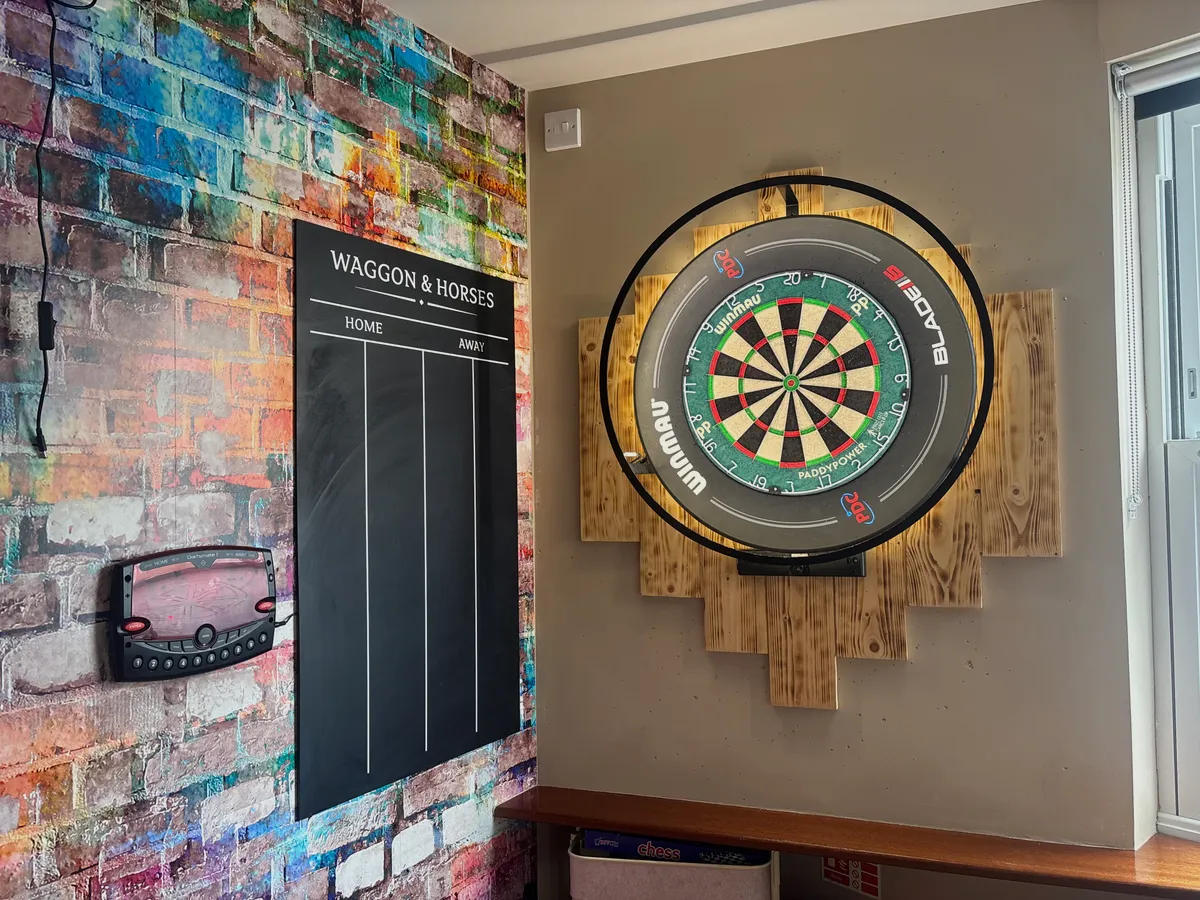 The darts corner at The Waggon and Horses, with a scoreboard and graffiti wall